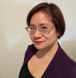 The author wearing a purple blazer in front of a white background.